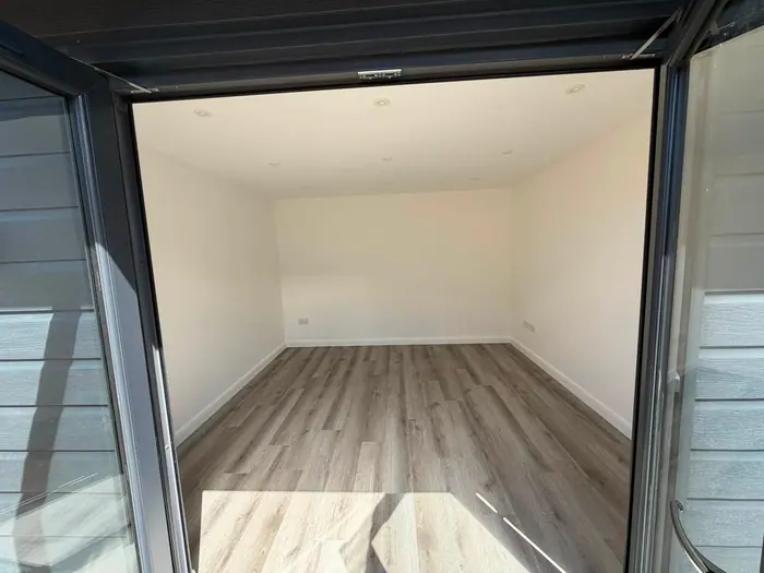 A finished interior with fresh plaster, painted walls and a wood-effect floor