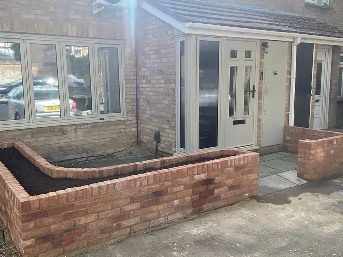Finished sandstone patio and red-brick planters by composite garden doors